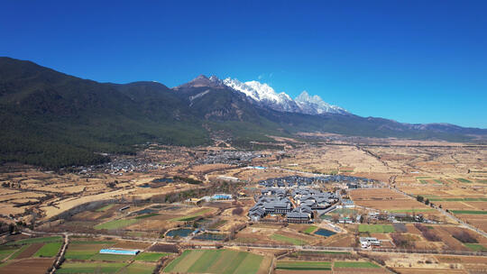 航拍云南丽江束河古镇稻田村庄与玉龙雪山