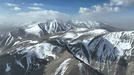 航拍蓝天白云下的新疆喀什地区雪山风光