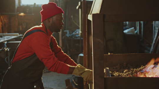 非裔美国铁匠在锻造火灾中加热金属棒