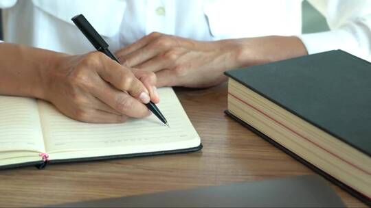 人手握笔在本子上写字工作