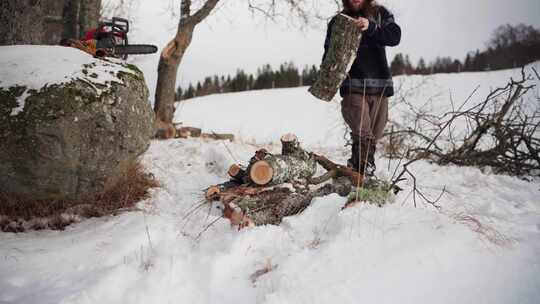 男人在雪地里堆积切割的原木。-特写镜头