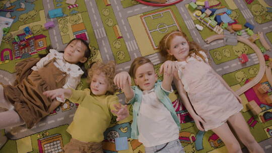 四个孩子躺在地毯上视频素材模板下载