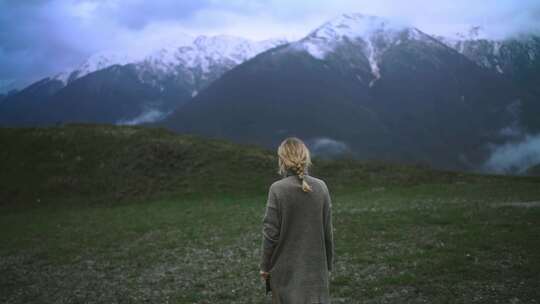 女人独自走在雪山脚下