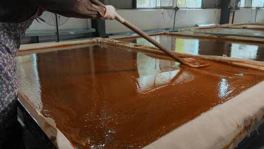 工业糖厂生产糖浆糖水均匀摊平晾晒凝固视频素材模板下载