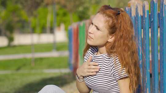 年轻女子在户外呼吸急促。