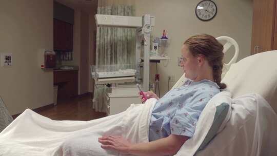 临产妇女在医院病床上等待，直到她的丈夫冲
