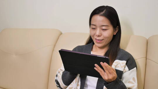 亚洲中国女性居家坐沙发办公玩手机上网购物