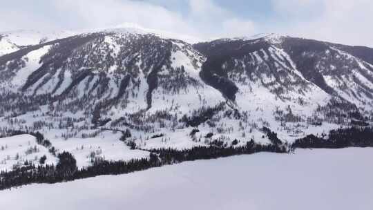 航拍新疆冬季喀纳斯湖雪景雪山森林冰河晨雾