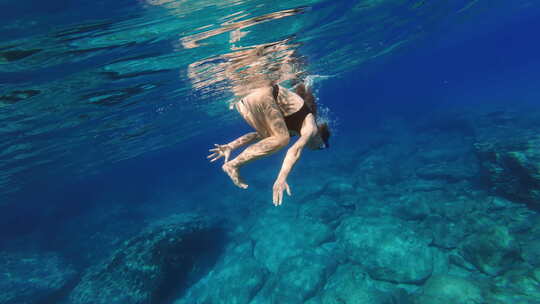 快乐女孩戴着面具在海里潜水游泳水下探索