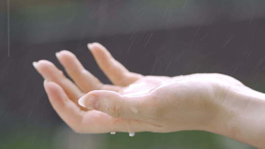 雨中的手。模糊背景下的手在雨中淋湿