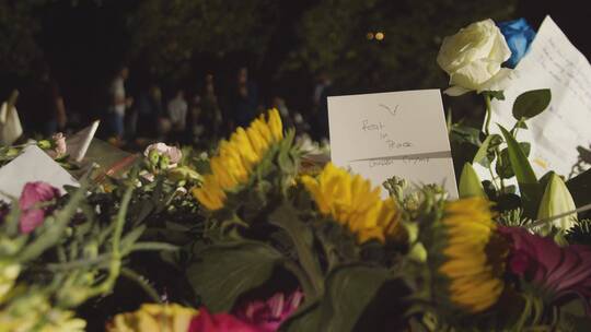 绿色公园花卉贡品和哀悼者特写镜头