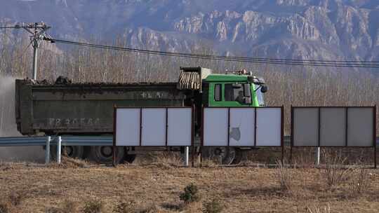 公路旁行驶的绿色大卡车