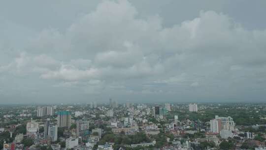 空中俯瞰城市全景，高楼大厦林立，云层涌动