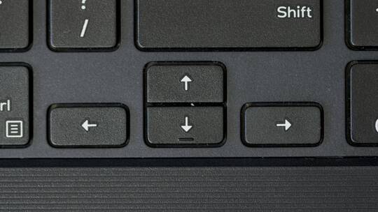 手指按压箭头键盘按钮的俯视图