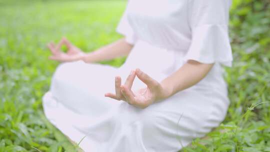 穿白裙子的女子盘坐在草地上打坐冥想 唯美