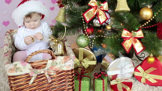 小婴儿坐在圣诞树旁