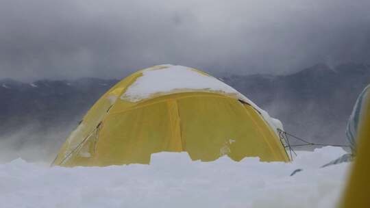 大风中的新疆慕士塔格峰雪山的登山者C1营地