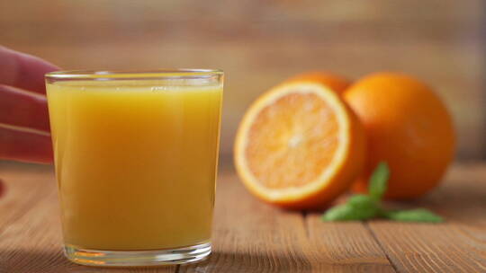 手拿起一杯鲜榨橙汁