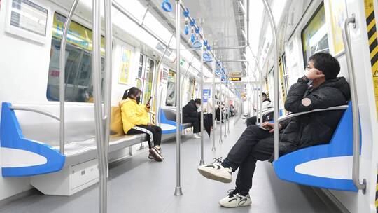 乘客在地铁车厢内使用手机