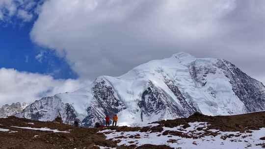 航拍垭口观看贡嘎山区雪山群峰的徒步旅行者