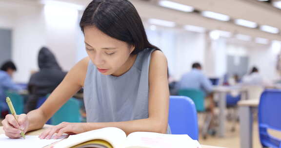 年轻女子在大学图书馆学习