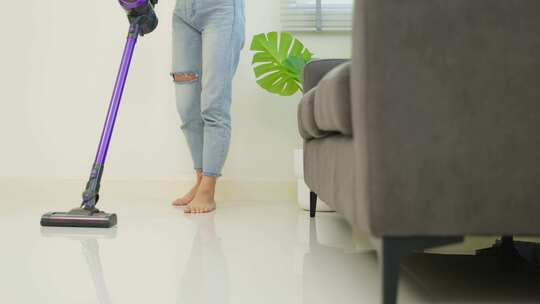 亚洲清洁服务女工在家打扫客厅。