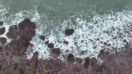 海岸礁石沙滩海水拍打礁石阴天海滩海浪冲刷