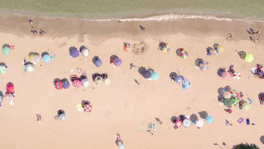 带彩色雨伞的拥挤夏日海滩的顶级照片