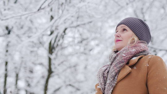 女人欣赏冬季雪景的低角度拍摄