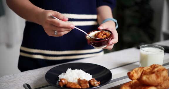 年轻女子正在把食物放在盘子里，准备在家里