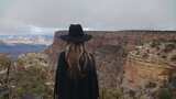 穿着黑色衣服戴着帽子的女人站着眺望大峡谷高清在线视频素材下载