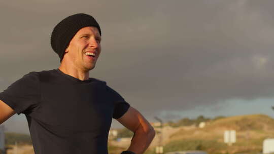 户外剧烈锻炼后戴着手套呼吸的疲惫运动员