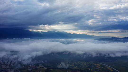 清晨的太阳光透过云层打在山川云雾之上