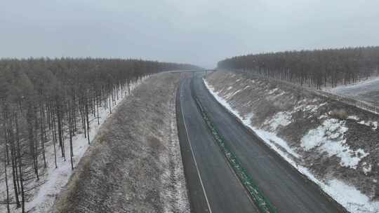 初春风雪大兴安岭林区道路上行驶的汽车