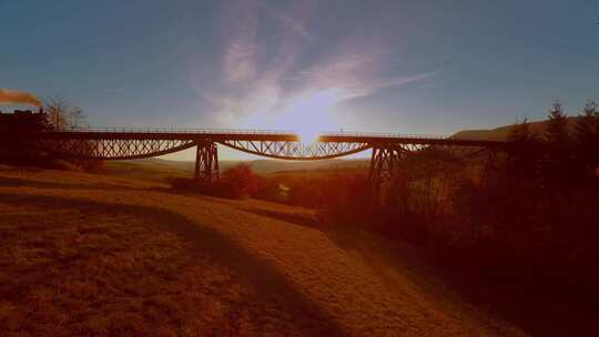 日落黄昏下火车驶过桥梁