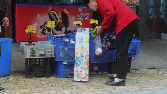 中老年人在路边买菜选辣椒