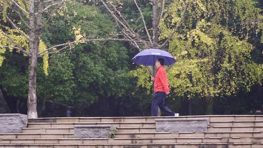 秋天雨中散步的行人