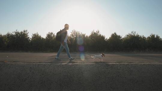 男人和狗在公路上散步视频素材模板下载