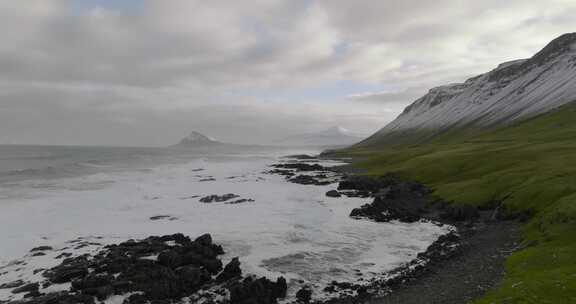 冰岛海岸格陵兰海岩石海岸上空的空中运动，绿草如茵