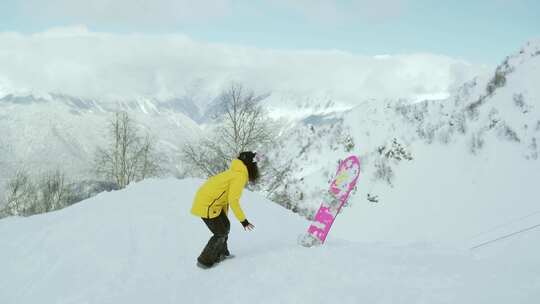 穿着黄色夹克的女人正在单板滑雪