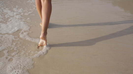 女生走在沙滩，流下脚印