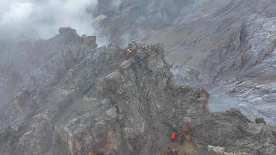 航拍攀登雪宝顶雪山的登山者翻越骆驼背