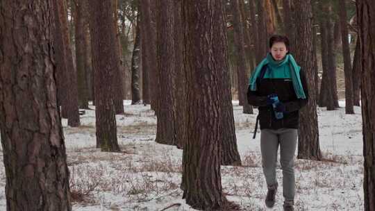 一名孤独的男性游客在白雪皑皑的松林中航行