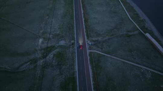 黄昏时分航拍汽车行驶在赛里木湖环湖公路上