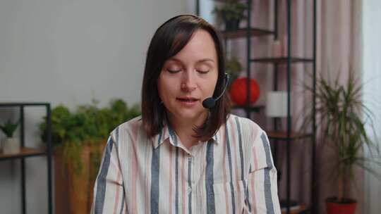 戴耳机的年轻女性自由职业者呼叫中心或支持服务接线员帮助热线交谈