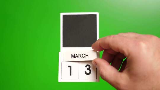 03.绿色背景上日期为3月13日的日历。