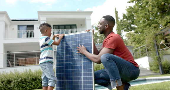 一名非裔美国人和他的儿子在家户外安装太阳