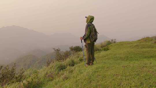 登山者在山顶手持登山杖眺望远方