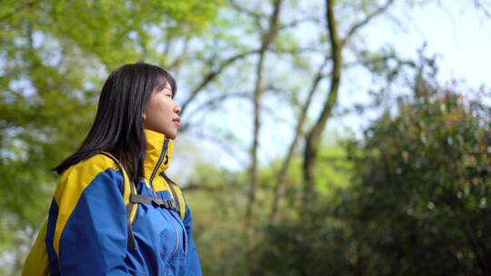 阳光明媚的春天年轻女孩拿着相机在路上拍照