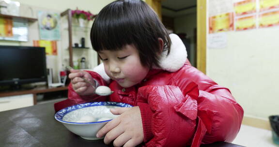 小孩在吃新年春节吃元宵汤圆